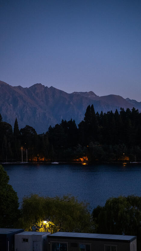 Nighttime lake/shoreline with The Remarkables in the background